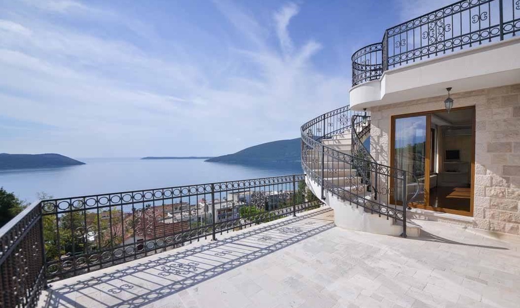Spacious villa terrace in Herceg Novi, Montenegro, with wrought-iron railings, a spiral staircase, and panoramic sea views.
