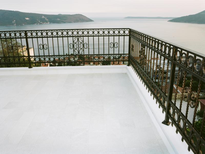 Spacious terrace with wrought-iron railing and panoramic views of the sea and mountains, villa in Herceg Novi, Montenegro.