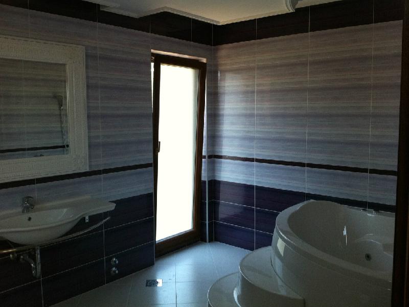 Bathroom with a corner bathtub and mirror in a villa in Herceg Novi, Montenegro: modern tile finish.