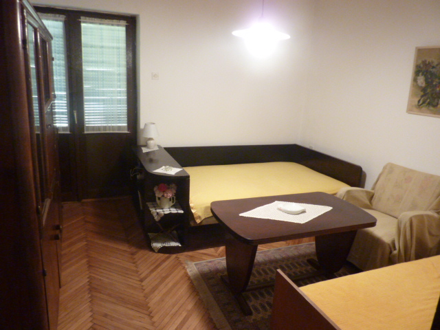 Living room in a house in Kumbor, Montenegro: parquet floor, dark wooden furniture, sofa, and dining table.