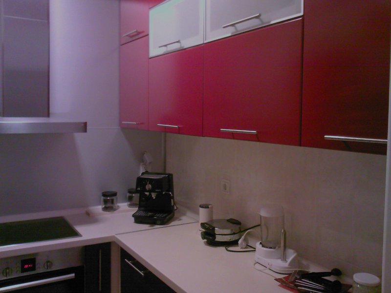 Modern kitchen with red fronts and built-in appliances in an apartment for sale, Budva, Montenegro.