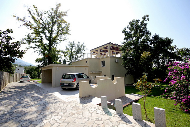 Two-story house in Sutomore, Montenegro: private parking, garage, green grounds, and a rooftop terrace with a pergola.