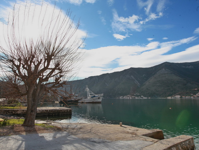 View of the sea and mountains from the pier by the house in Dobrota, Montenegro: waterfront, yachts, and picturesque bay landscape.