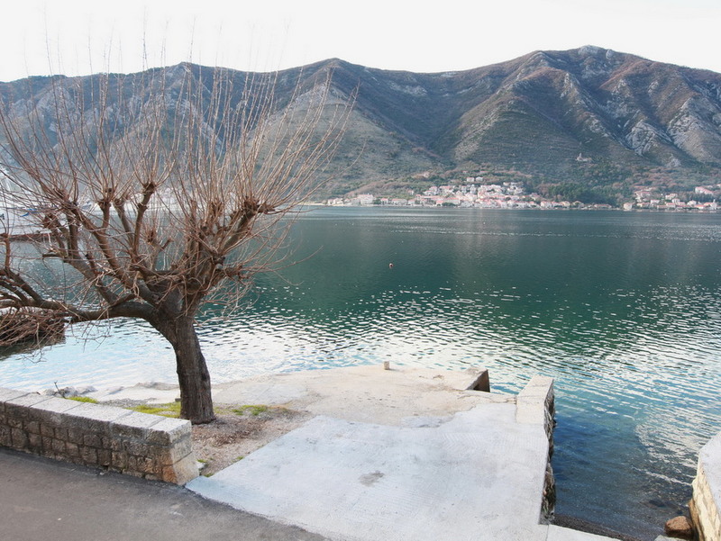 View of the Bay of Kotor and the mountains from a private pier by a house in Dobrota, Montenegro. Waterfront property with direct access to the sea.