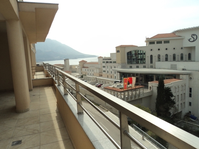 Spacious apartment balcony in Bečići, Montenegro, with a view of the Splendid hotel, the sea, and the mountains.