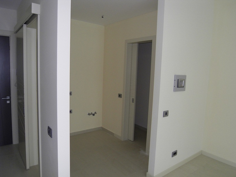 Interior of a modern apartment in Budva, Montenegro: light wall finishes, interior doors, and plumbing connections.