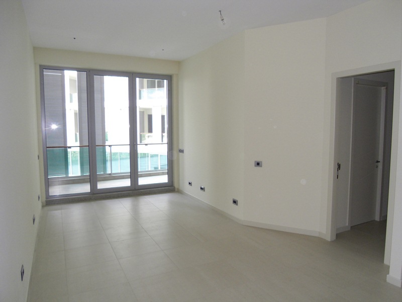 Bright living room with panoramic windows and access to the balcony in a new apartment, Budva, Montenegro.
