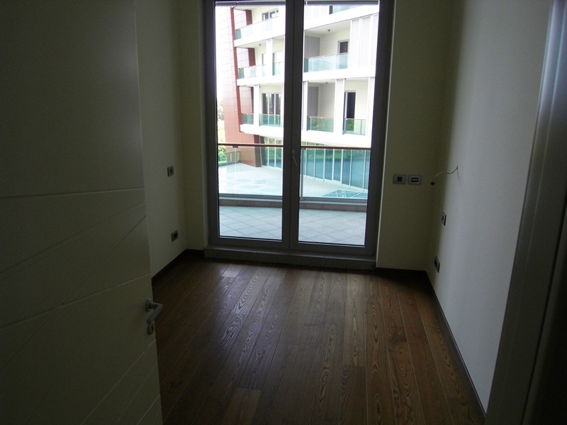 Bright bedroom with parquet flooring and access to the terrace in a modern apartment, Budva, Montenegro.