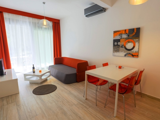 Living room in an apartment in Dobri Vody, Montenegro: modern furniture, dining area, and access to the terrace.