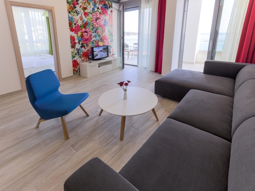 Living room with a gray sofa and sea view in an apartment, Dobri Vody, Montenegro: modern interior with bright decor.