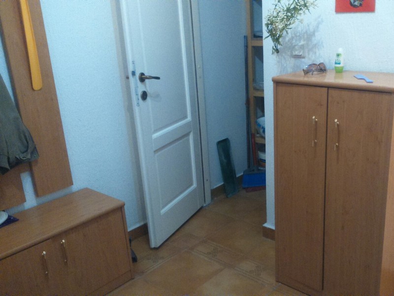 Hallway with wooden furniture and a light-colored door in an apartment for sale in Budva, Montenegro.