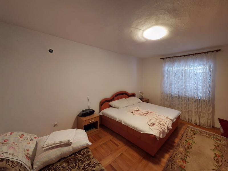 Cozy bedroom with a double bed and parquet flooring in a house for sale, Shushan district, Montenegro.