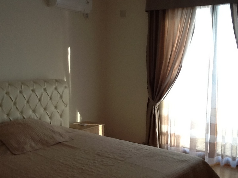 Bedroom in a house in Shushan, Montenegro: a double bed with a soft headboard, a bright interior, and access to the balcony.