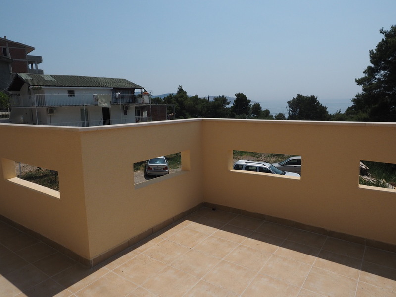 Spacious open terrace with tiled flooring in a house in Bar, Montenegro, with sea and surrounding views.