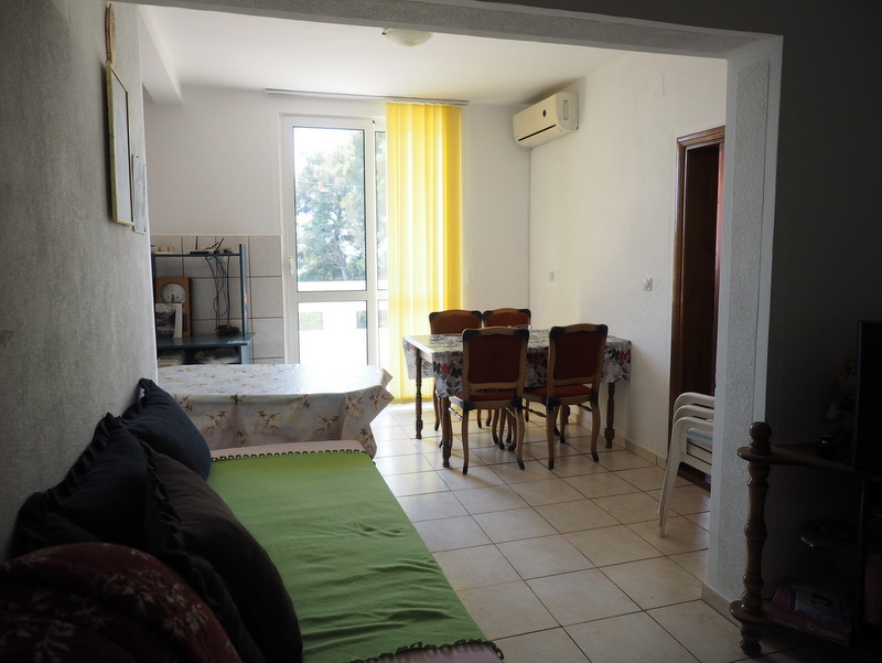 Living room with dining area in a house in Bar, Montenegro: a bright room with tile flooring, furniture, and access to the terrace.