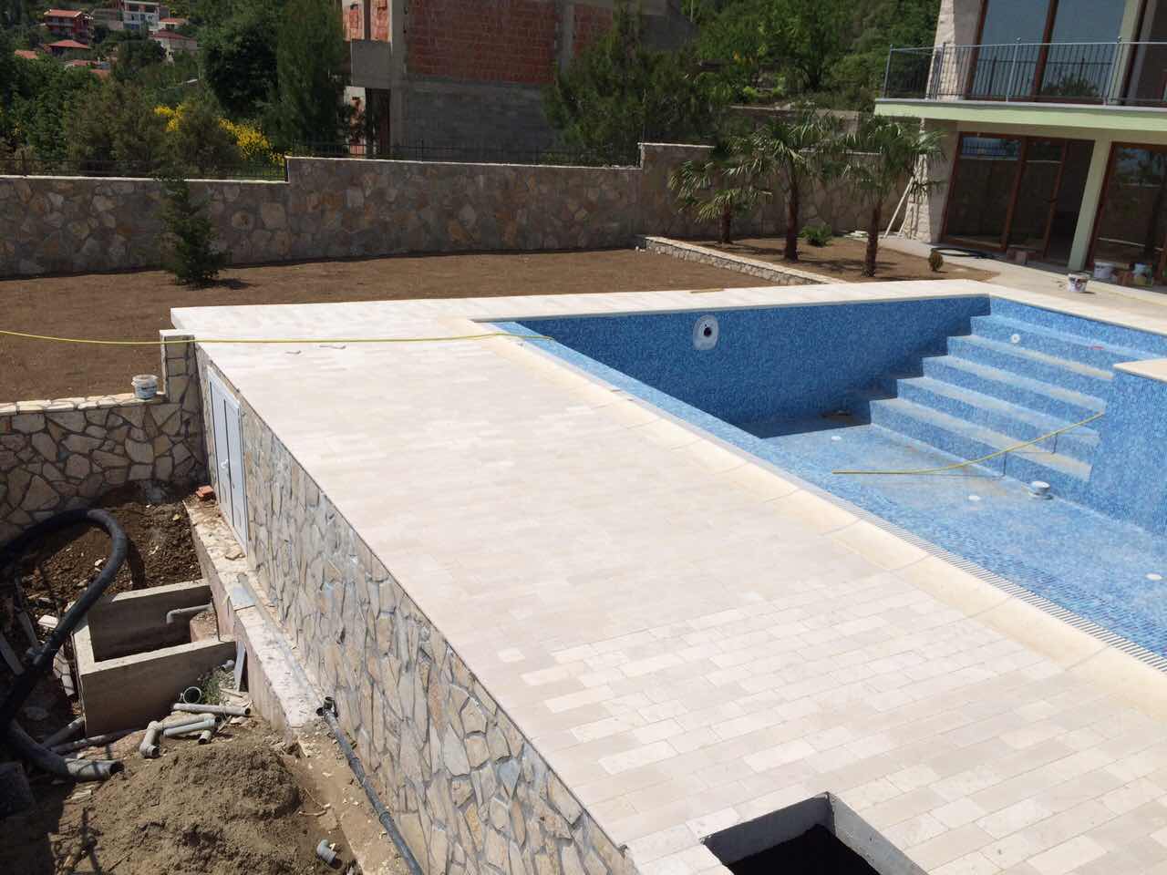An under-construction pool with mosaic finish and a stone terrace at a villa in Shushan, Montenegro.