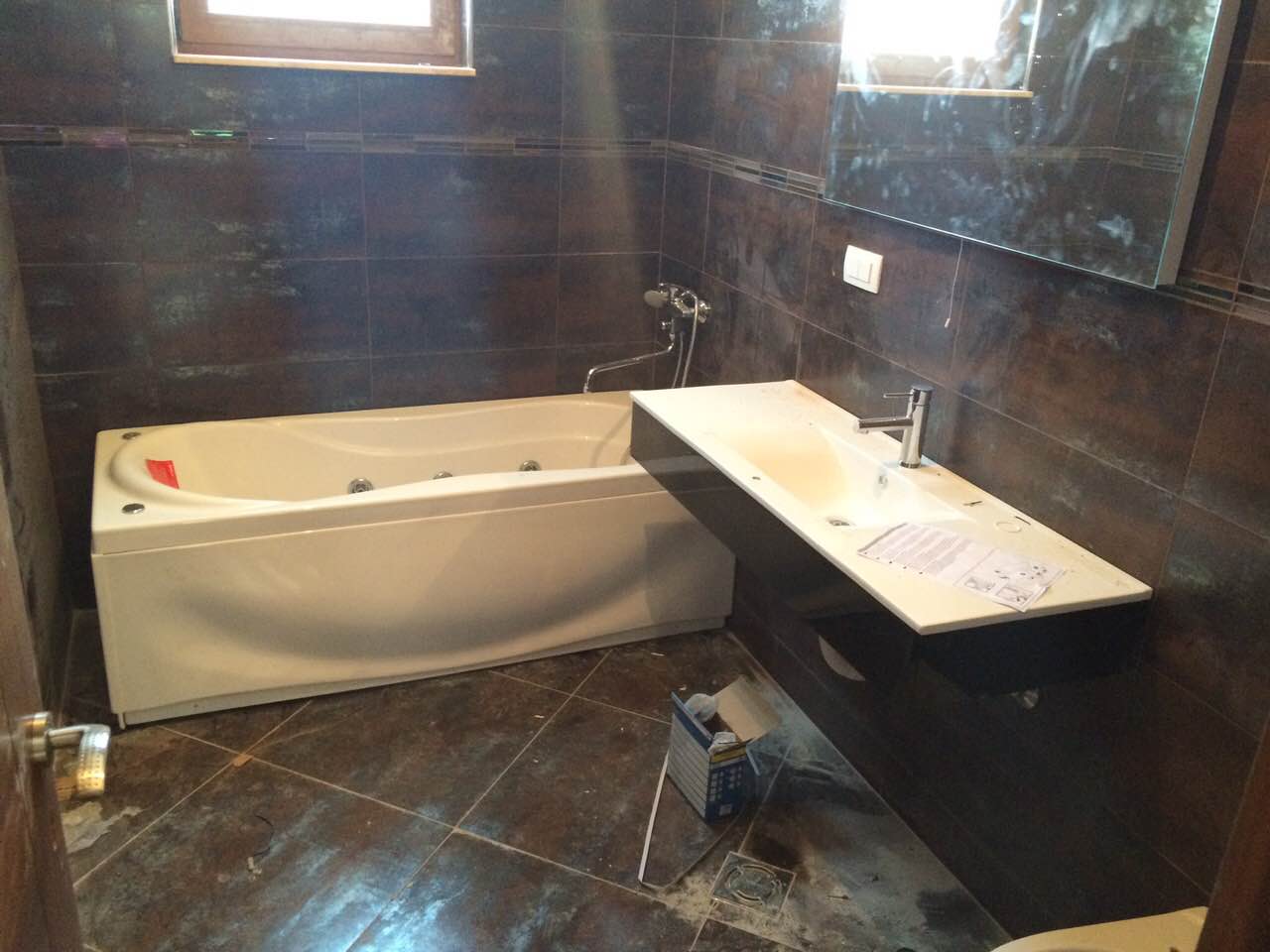 Bathroom with a jacuzzi and dark tiles in a villa in Shushan, Montenegro. Modern fixtures and interior finishes.