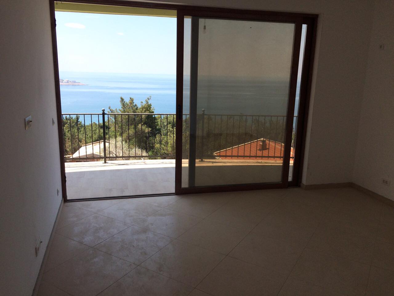 Living room with panoramic sea views and a terrace in a villa in Šušanj, Montenegro: light finishes and sliding doors.