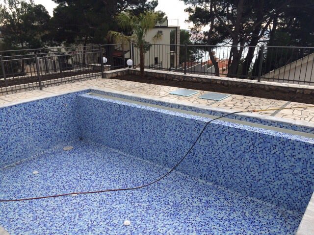 Open-air pool with mosaic finish on the house terrace in Shushan, Montenegro, overlooking the sea and pine trees.
