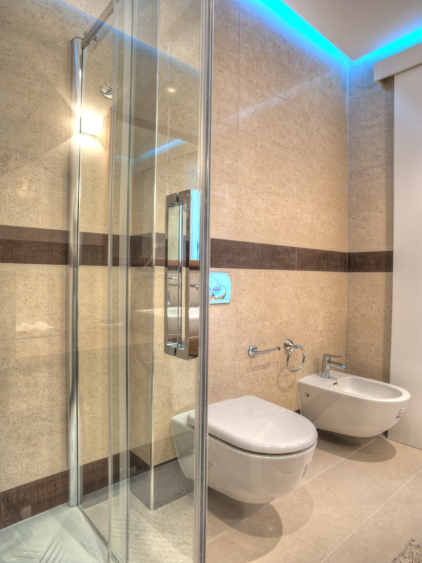Modern bathroom in an apartment in Budva, Montenegro: shower cabin, wall-mounted toilet, bidet, and LED lighting.