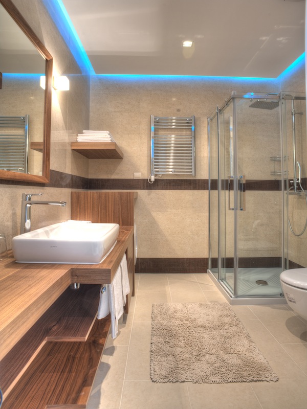 Modern bathroom with a shower cabin and wood finishes in an apartment in Budva, Montenegro.