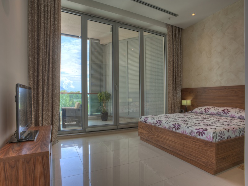 Modern bedroom with panoramic windows and access to the terrace in an apartment, Budva, Montenegro.