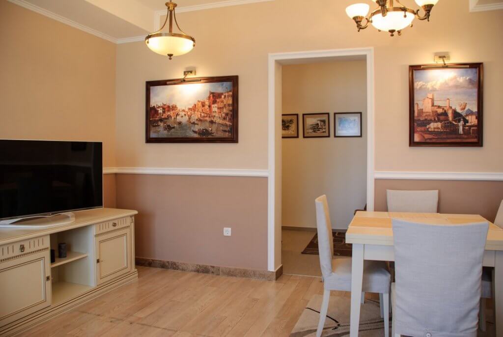 Cozy living room with dining area in an apartment, Kostanica, Montenegro: light furniture, paintings, and classic decor.