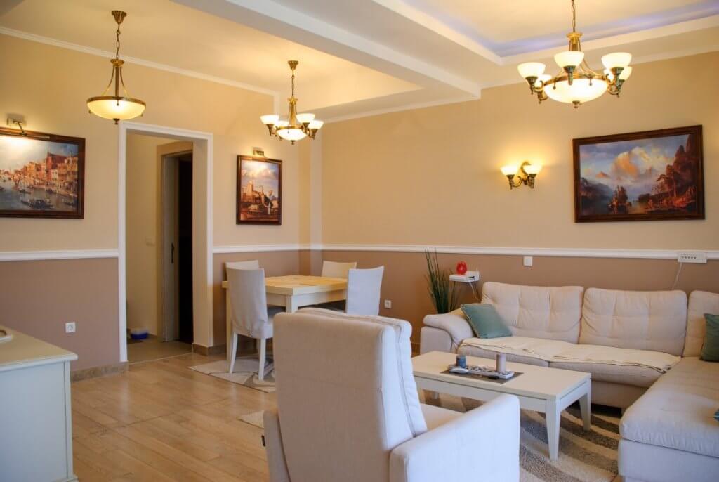 Bright living room with white furniture and a classic interior in an apartment for sale in Kostanica, Montenegro.
