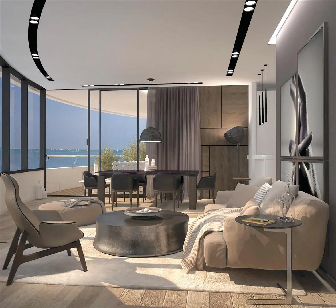 Modern living room with a beige sofa, round coffee table, dining area, and ocean view through glass walls.