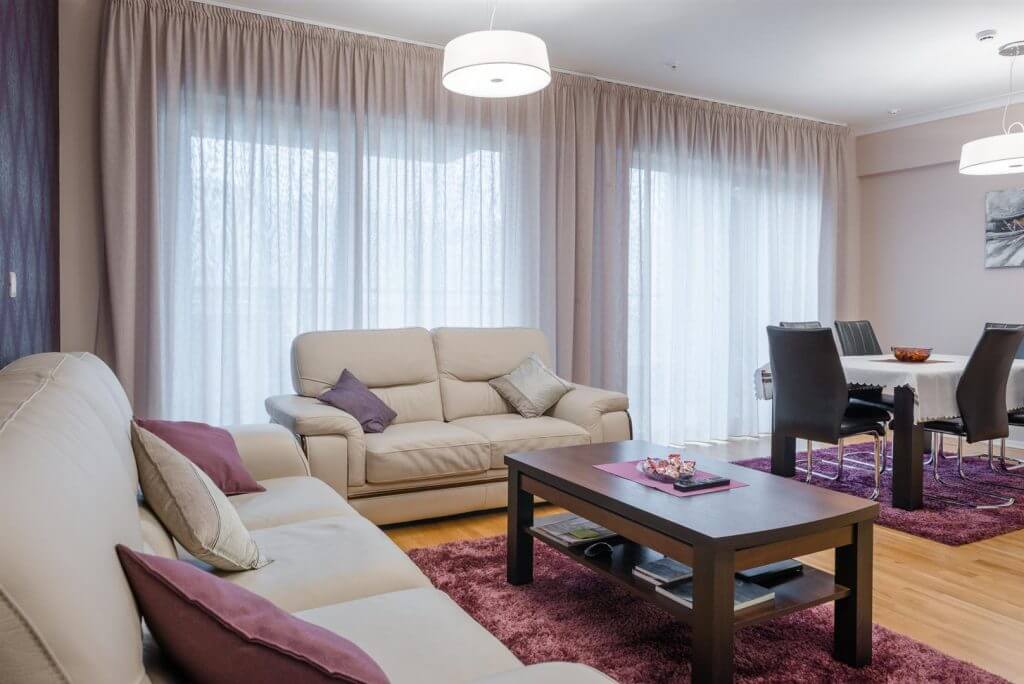 Bright living room with leather sofas and a dining area in an apartment in Bečići, Montenegro. Modern interior.