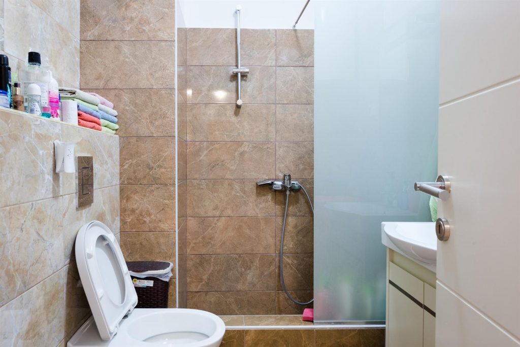 Modern bathroom with a shower cabin and beige tiles in an apartment in Bečići, Montenegro.