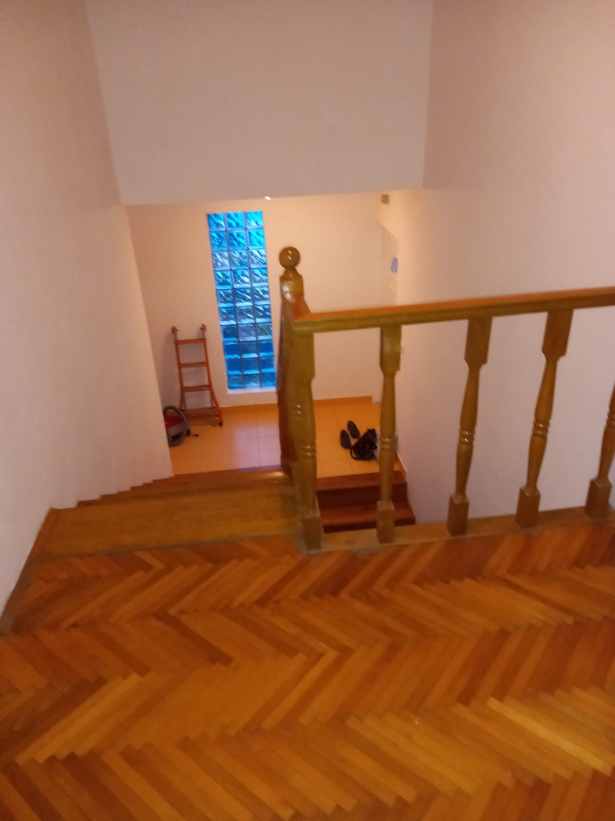 Wooden staircase with balusters and parquet in a hotel in Budva, Montenegro, with a decorative glass block window.