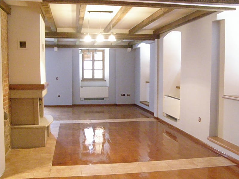 Spacious living room with a fireplace and wooden beams in a villa in Stoliv, Montenegro: interior with a glossy floor.