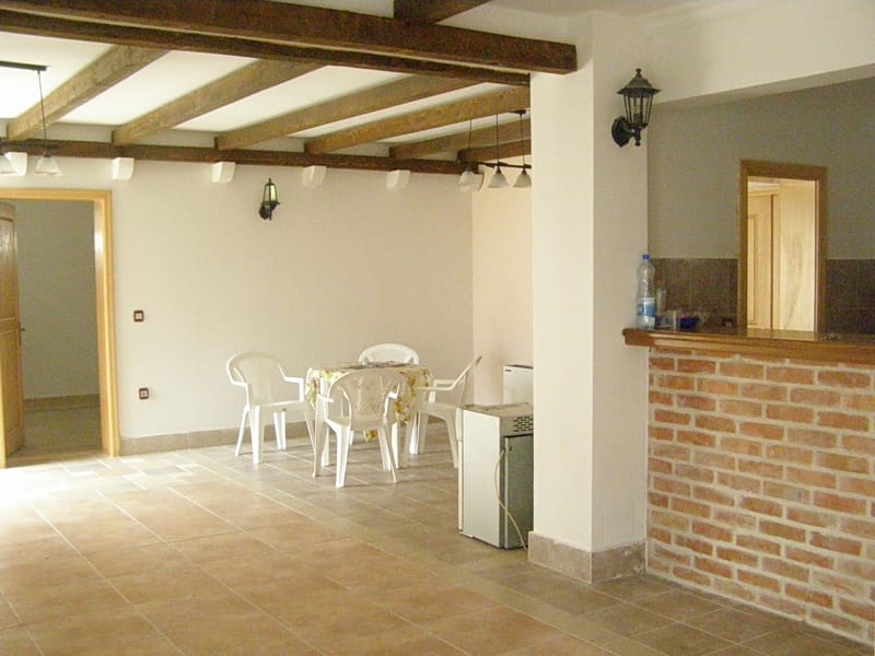Living room with wooden beams and a brick bar counter in a villa in Stoliv, Montenegro.