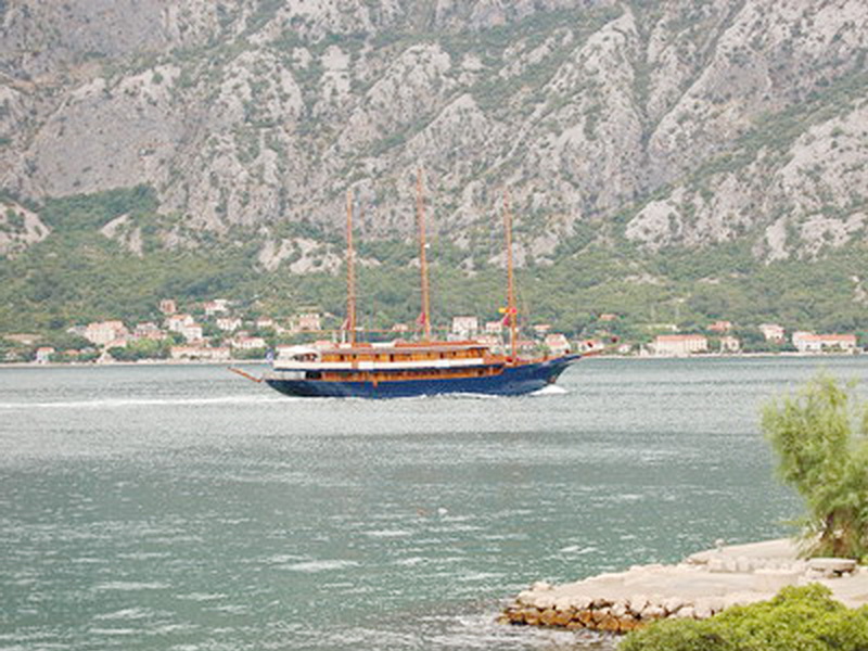 Sea view and a sailing yacht from a villa in Prčanj, Montenegro: a panorama of the bay and mountain scenery on the coast.