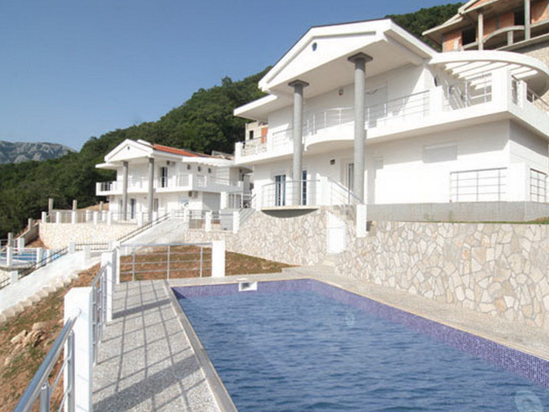 Two modern white villas with a pool and terraces in Bar, Montenegro, against a mountain backdrop.