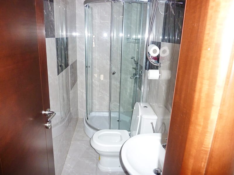 Modern bathroom with shower cabin in an apartment, Rafailovici, Montenegro: tiled finish and plumbing fixtures.