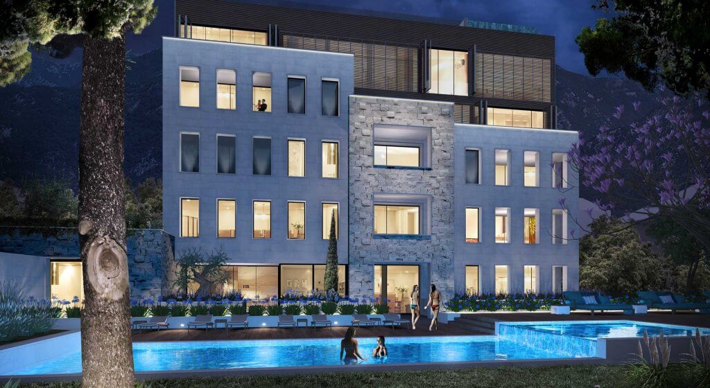 Modern residential complex with a pool and stone facade in Tivat, Montenegro, evening view of the building.