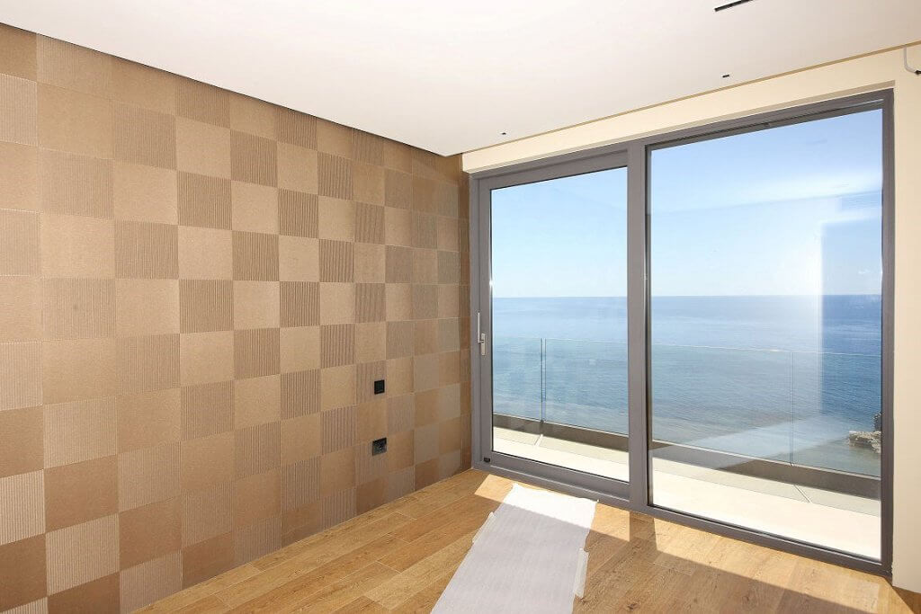 Living room with panoramic sea view in an elite villa in Budva, Montenegro: designer wall finishes and parquet flooring.