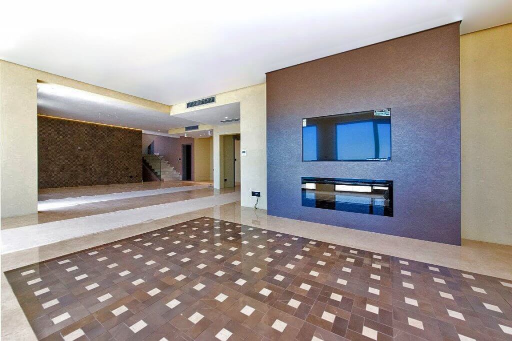 Spacious villa living room in Budva, Montenegro: modern design, marble floor, built-in fireplace, and TV area.
