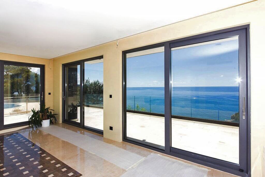 Living room with panoramic windows and sea view in a villa in Budva, Montenegro: bright interior and terrace.