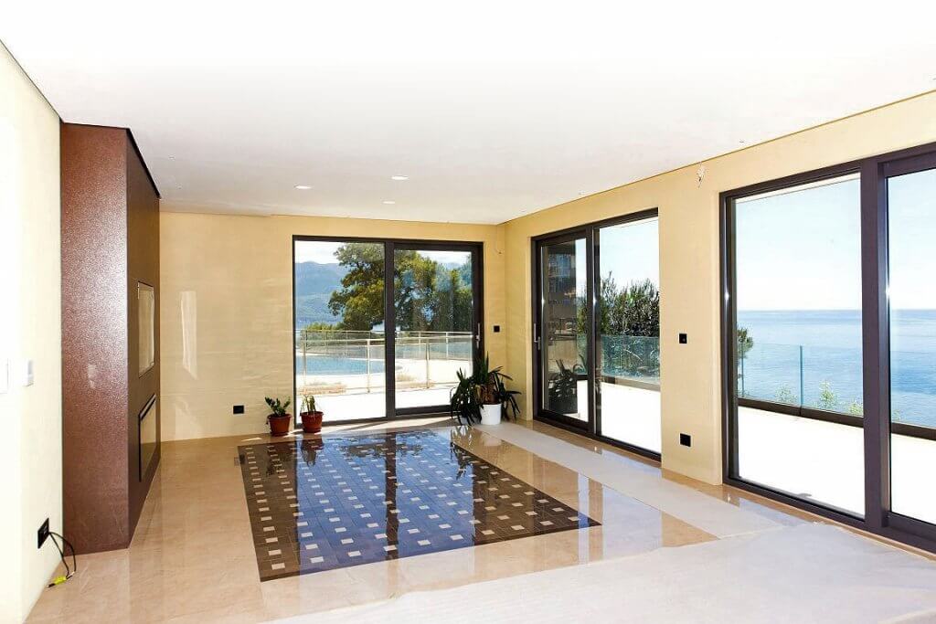 Living room with panoramic windows and sea view in an exclusive villa, Budva, Montenegro: marble floor and modern design.