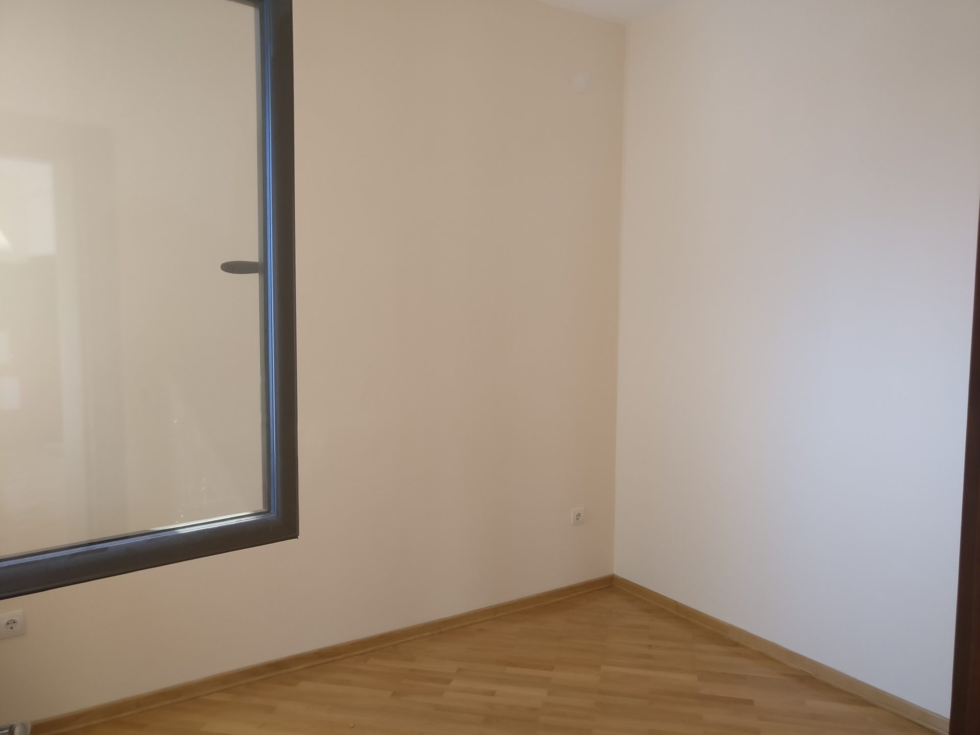 Bright living room with a panoramic window and parquet flooring in a house for sale, Shushan, Montenegro.