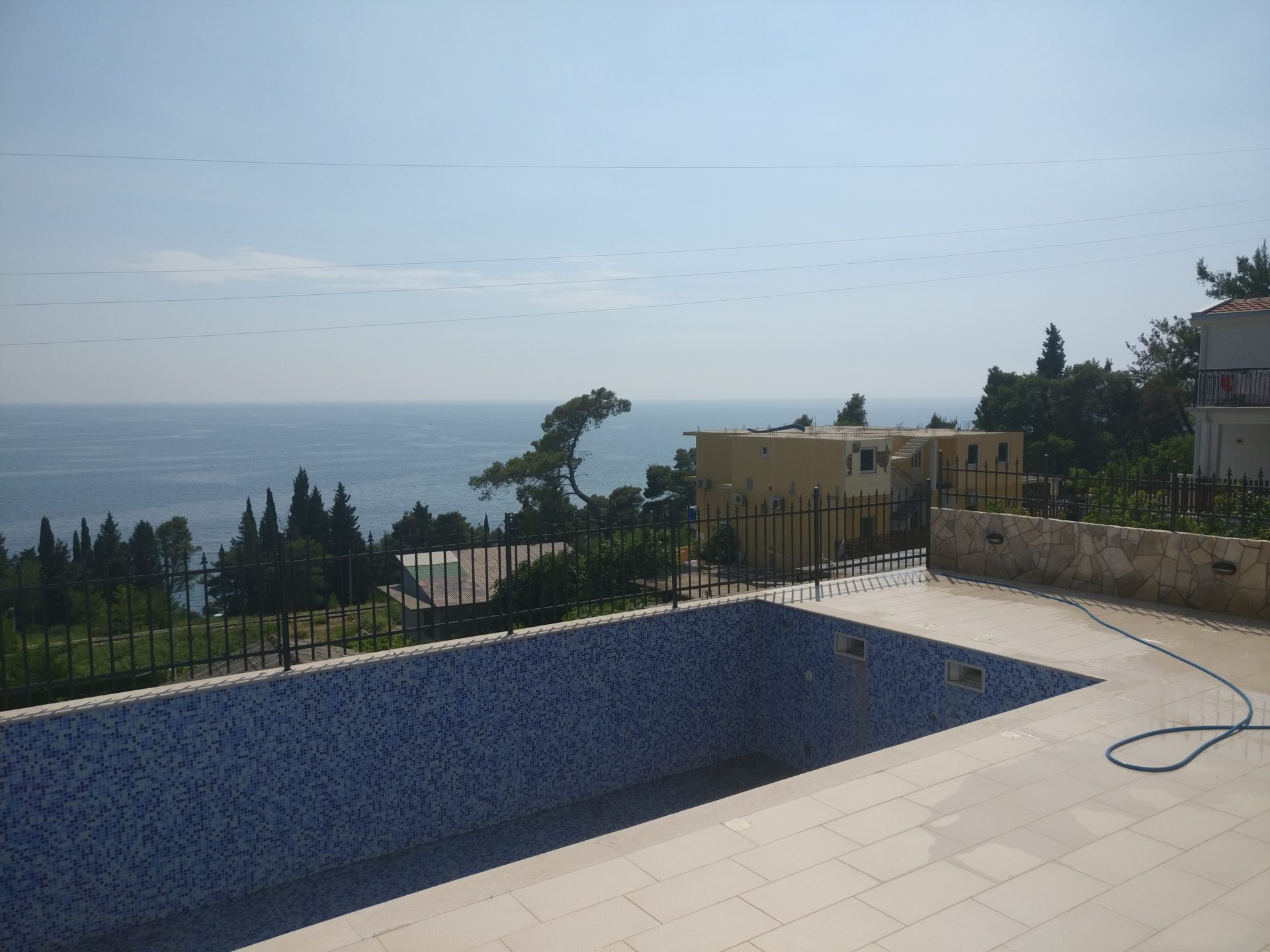 Sea view and a mosaic-tiled pool on the terrace of a house in Šušanj, Montenegro.