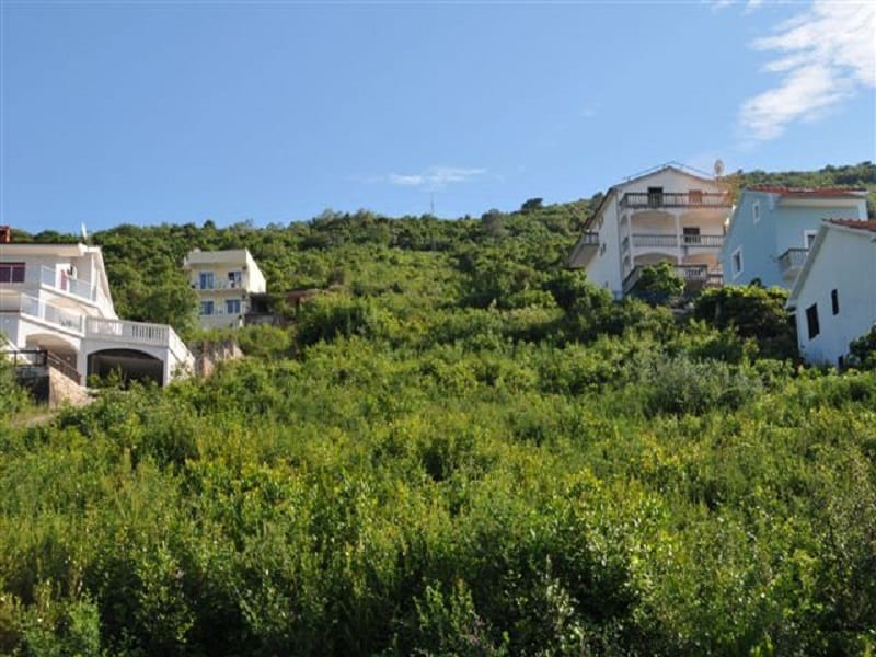 Building plot in Krašići, Montenegro: view of a hilly landscape with residential houses and greenery.