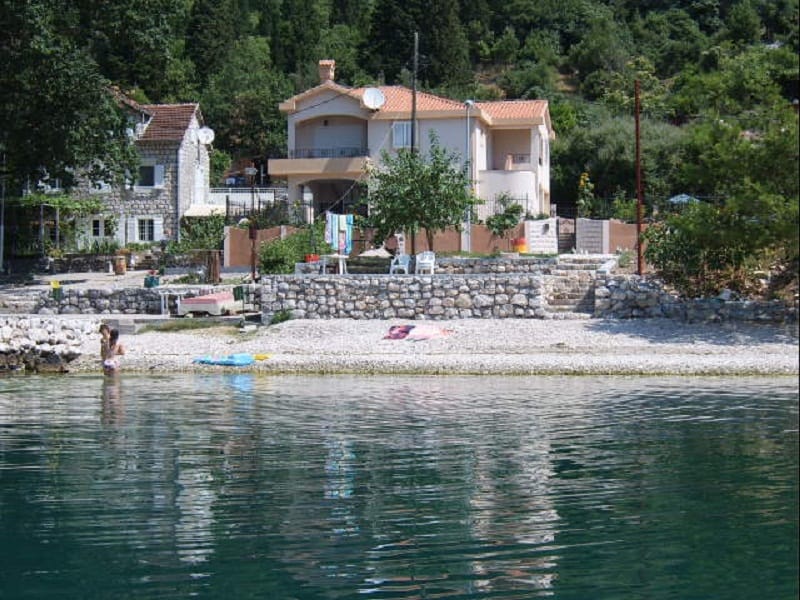 Two-story house with a terrace on the seafront in Orahovac, Montenegro, with a private pebble beach and garden.