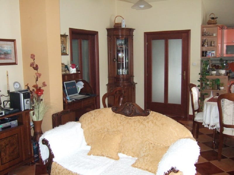 Living room interior in a house in Orahovac, Montenegro: classic wooden furniture, a soft sofa, and a dining area.