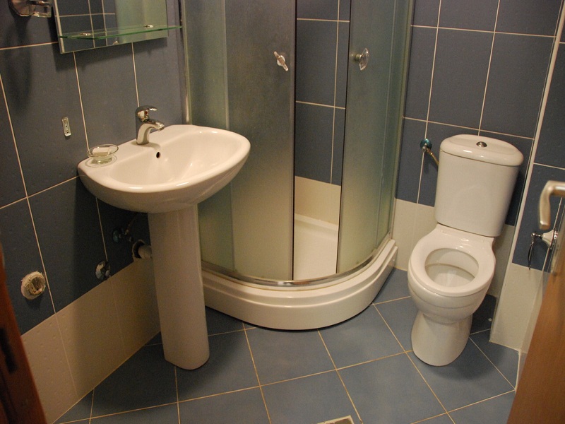 Bathroom with a shower cabin and blue tiles in an apartment for sale, Bečići, Montenegro.