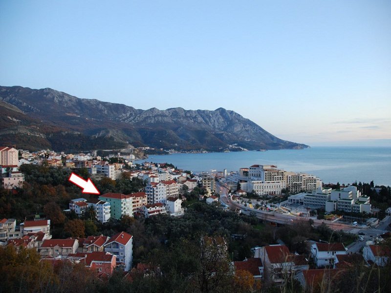 Panoramic view of a residential building in Bečići, Montenegro, overlooking the seaside and mountain landscape.