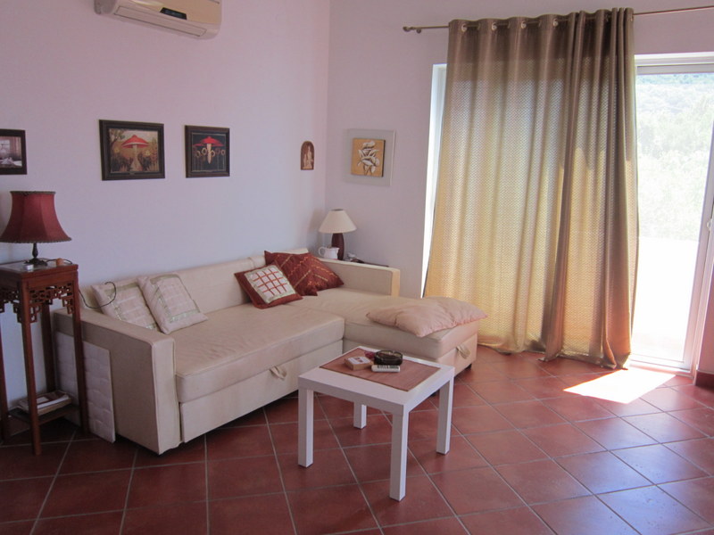 Bright living room with a beige sofa and terracotta floor in a house for sale, Uteha, Montenegro.